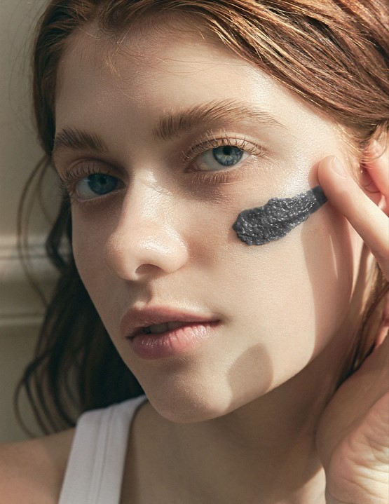 Model wearing smear of Arencia Black Tea and Yuzu Mochi Cleanser on her cheek