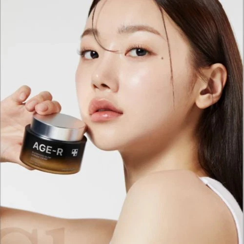 Medicube AGE-R Glutathione Glow Capsule Cream being held by a posing model