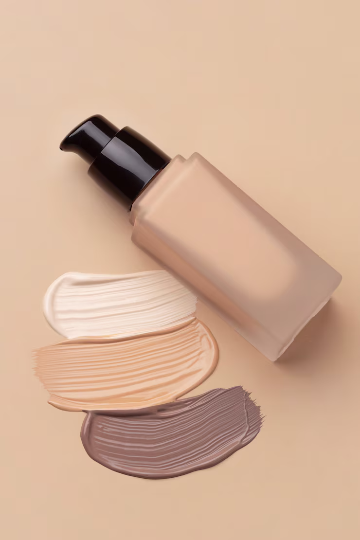Bottle of foundation lying next to test streaks of different shades