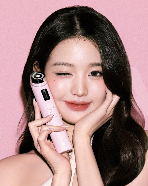 South Korean singer Jang Wonyoung posing with Medicube AGE-R Booster Pro Pink device