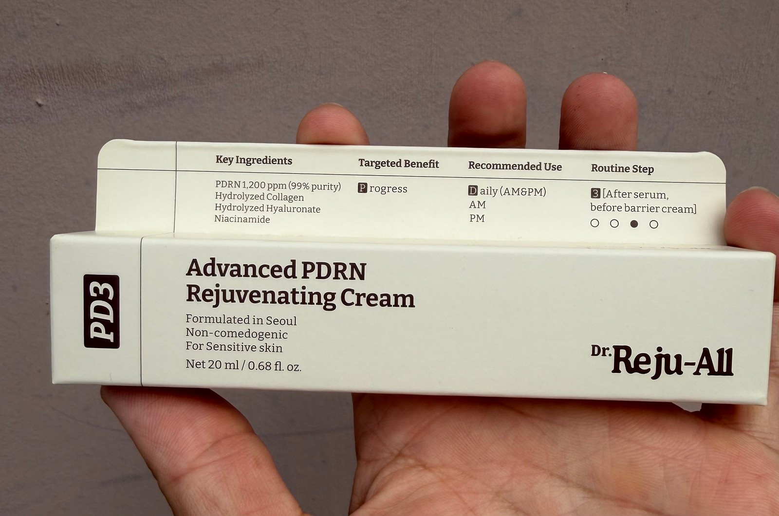 Dr Reju-All Advanced PDRn Cream packaging holding the tube in hand