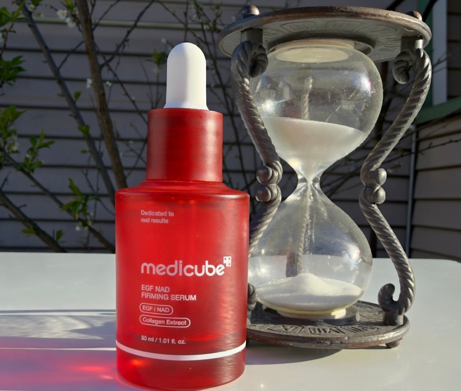 Medicube EGF NAD Firming Serum with collagen extract for anti-aging skincare displayed outdoors