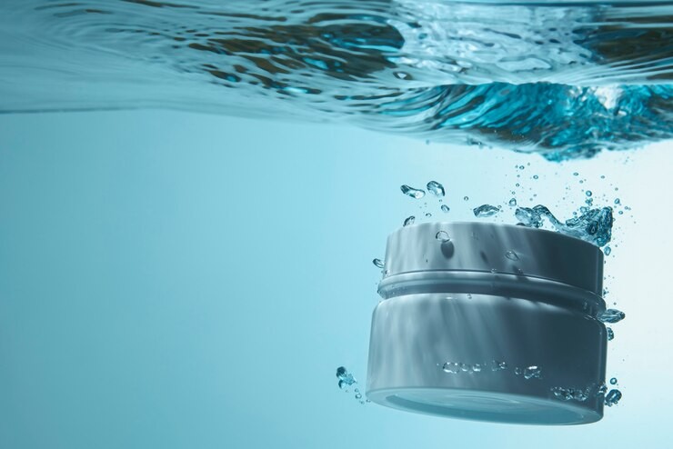 Jar of cream submerged in blue, clear water