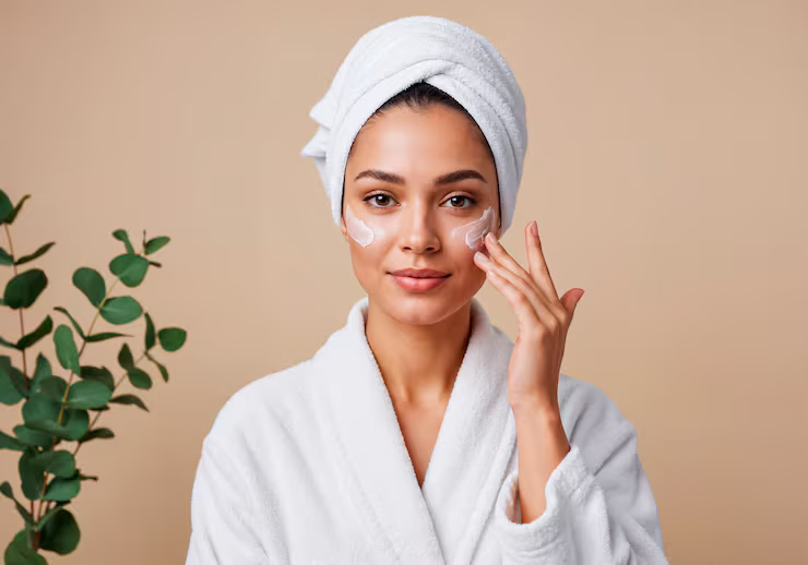 Woman Moisturizing her skin whilst in a bathrobe