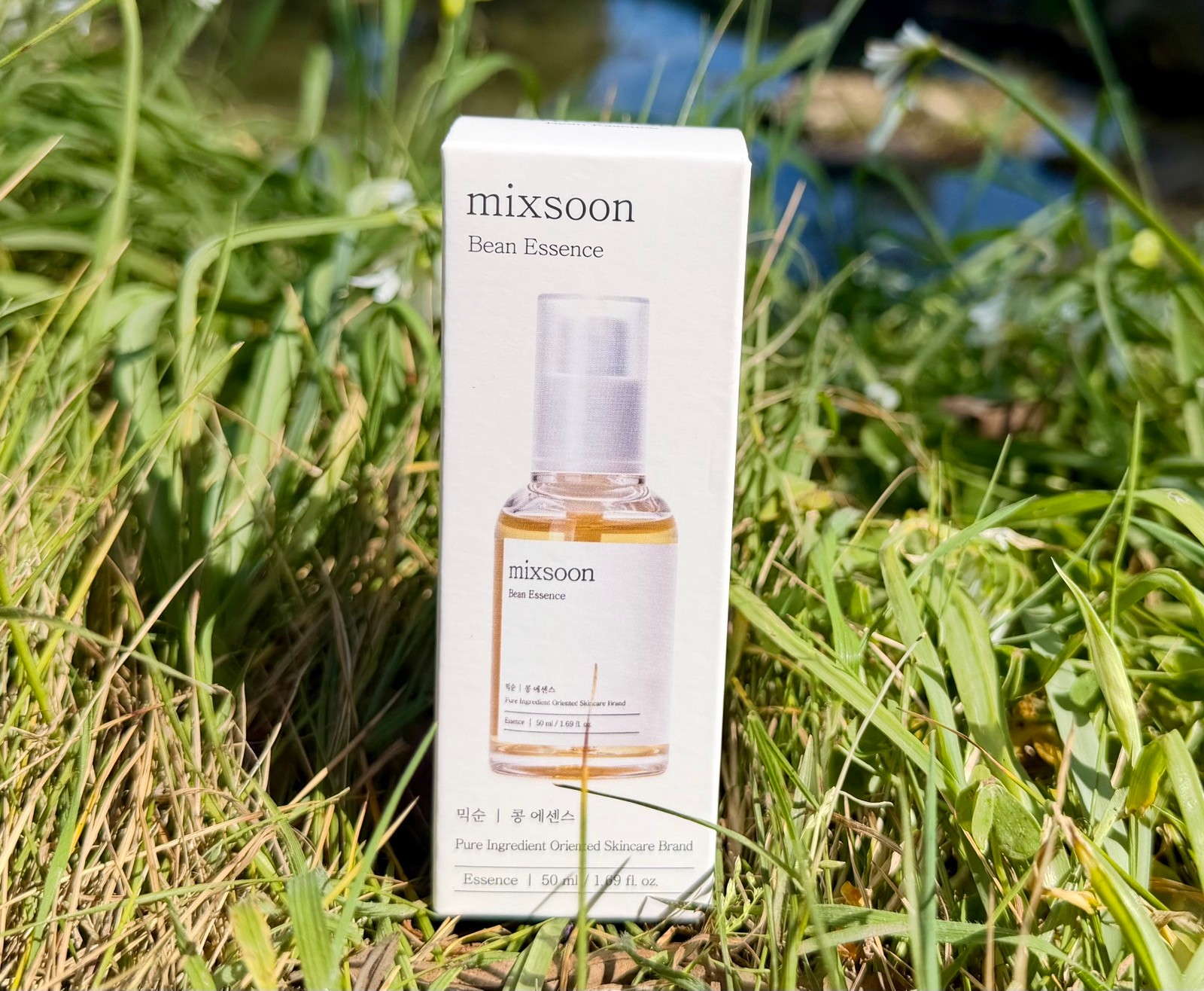 Mixsoon Bean Essence 50ml box standing in tall green grass for natural fermented Korean skincare