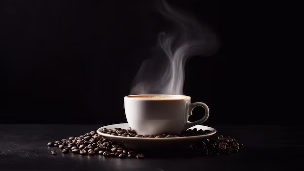Cup of steaming coffee on a bed of coffee beans