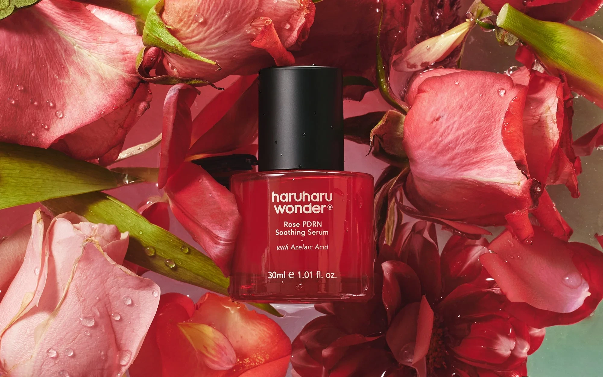 Haruharu Wonder Rose PDRN Soothing Serum resting on a pile of deep, rose petals