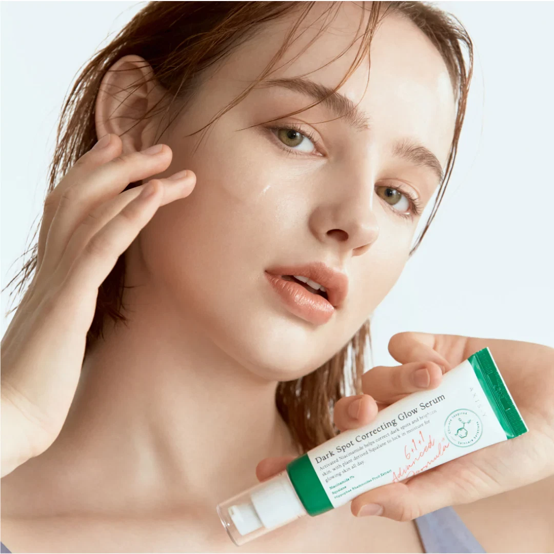 Axis Y Dark Spot Correcting Glow Serum being held by fabulous model