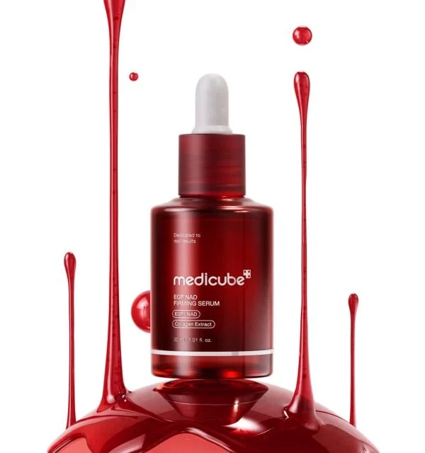 Medicube EGF NAD+ Firming Serum surrounded by ruby-red droplets