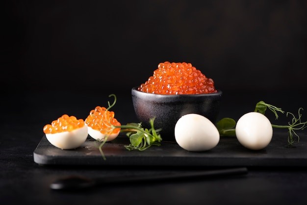 Tray off boiled eggs piles with fresh orange, salmon roe