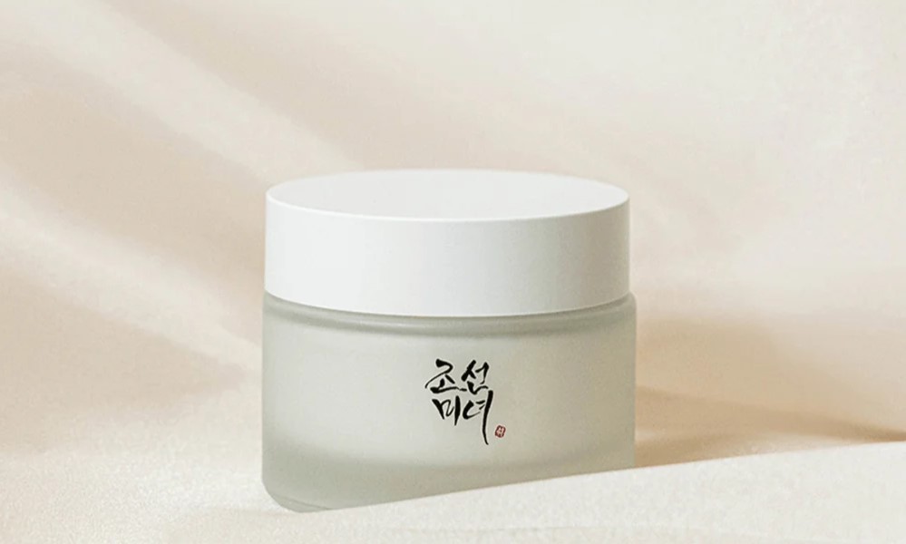 Beauty of Joseon Dynasty cream jar sitting on a background of white material in soft lighting.