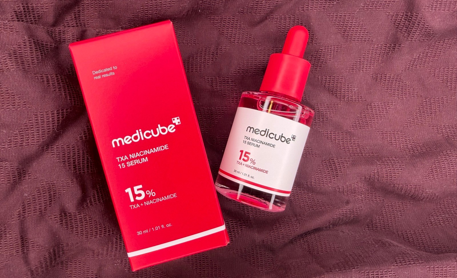 medicube txa niacinamide 15 serum with Box on the Red Sheet