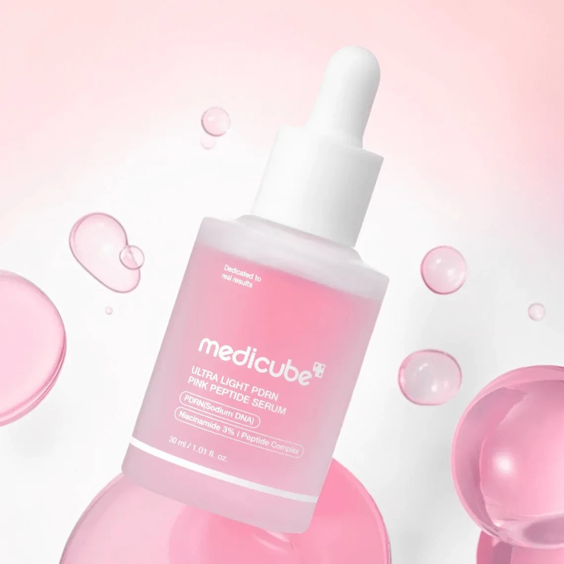 Medicube Ultra Light PDRN Pink Peptide Serum floating with pink bubbles