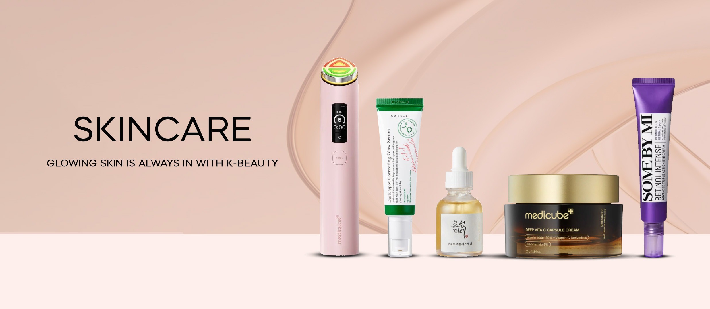 Gua Sha skincare arrangement with serum, oils and a floral branch