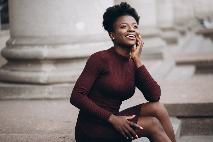 Young woman sitting on city step smiling in sunshine