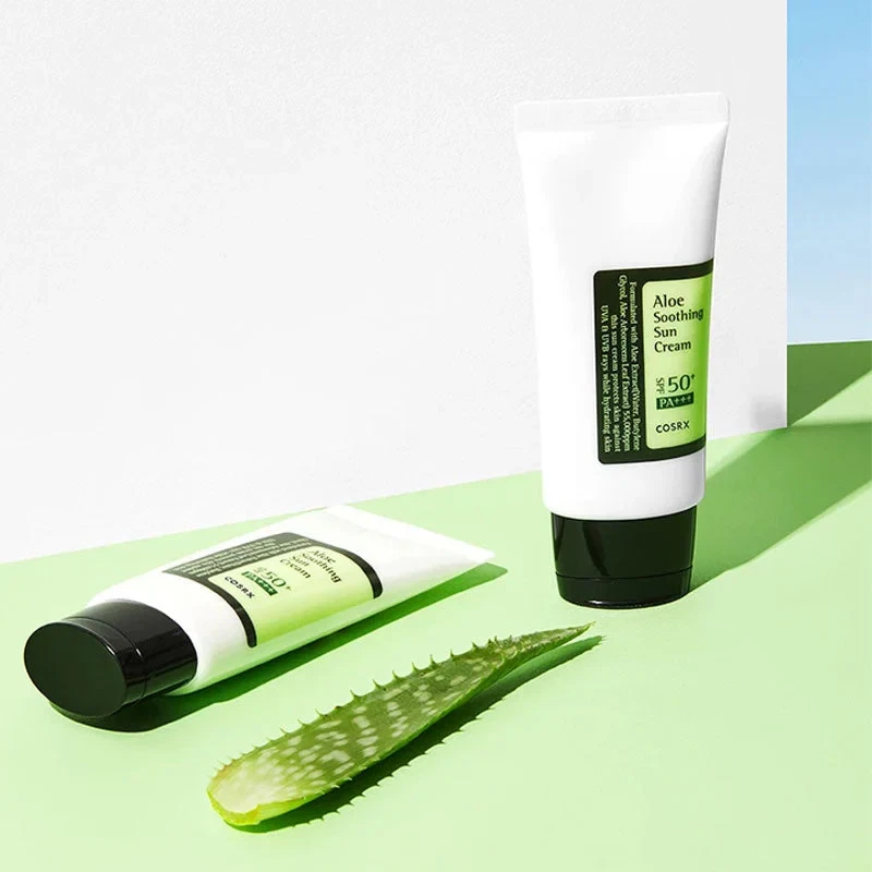 Cosrx Aloe Soothing Sun Cream bottles lying in sunny background with aloe leaf