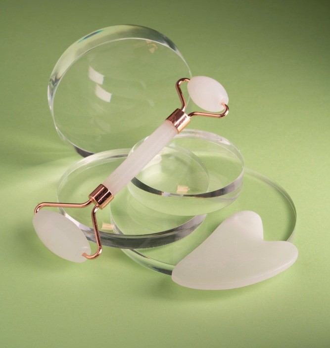 Skincare Tool Set-Up with massager and Gua Sha in green lighting