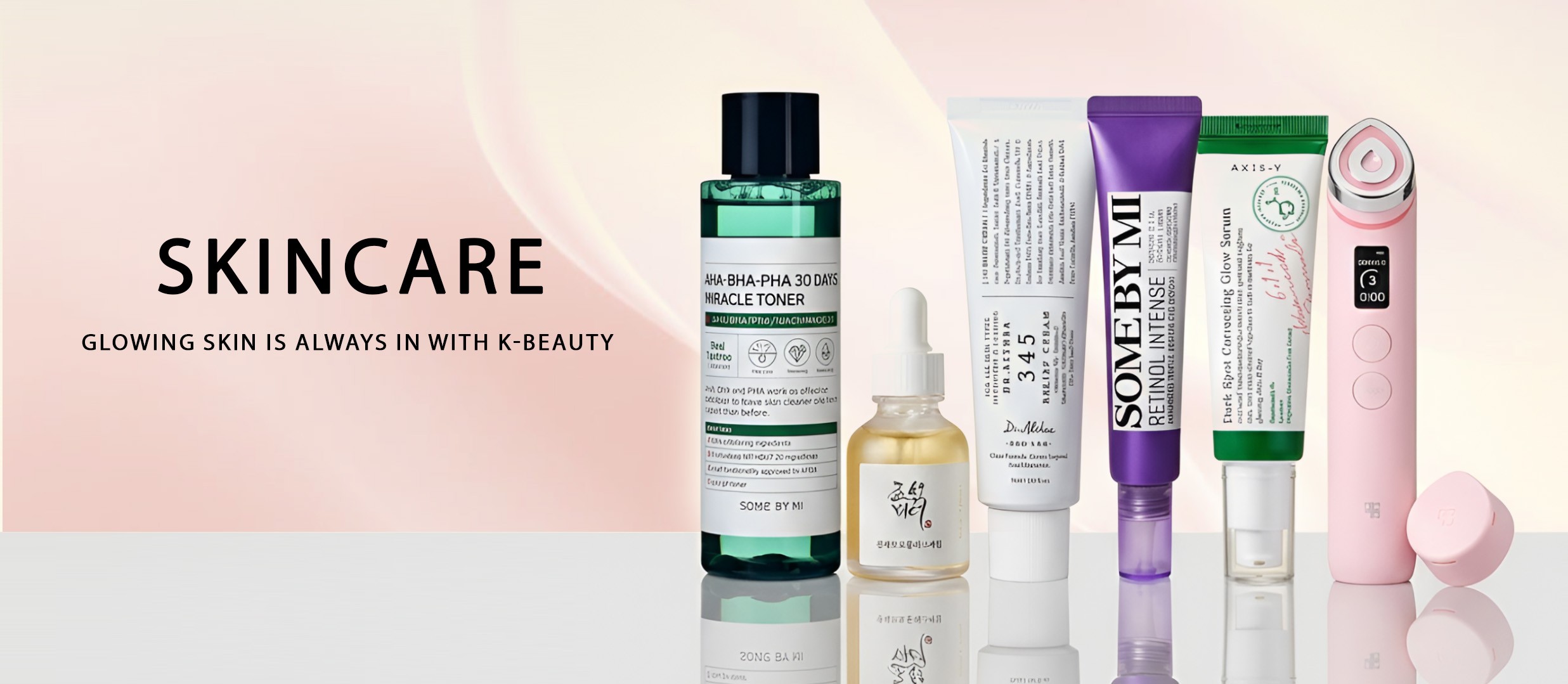 Gua Sha skincare arrangement with serum, oils and a floral branch