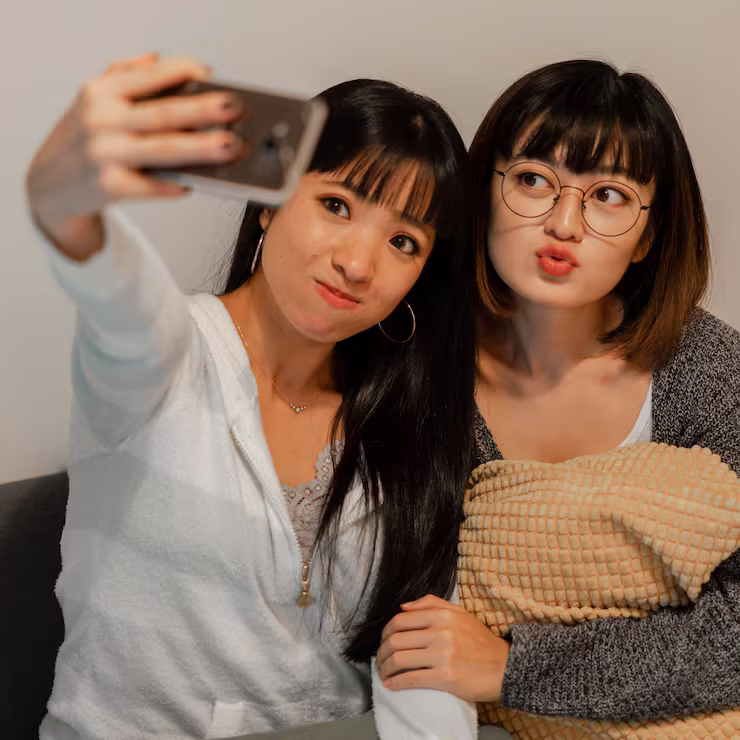 Two young Korean women posing for a selfie, looking casual and chic