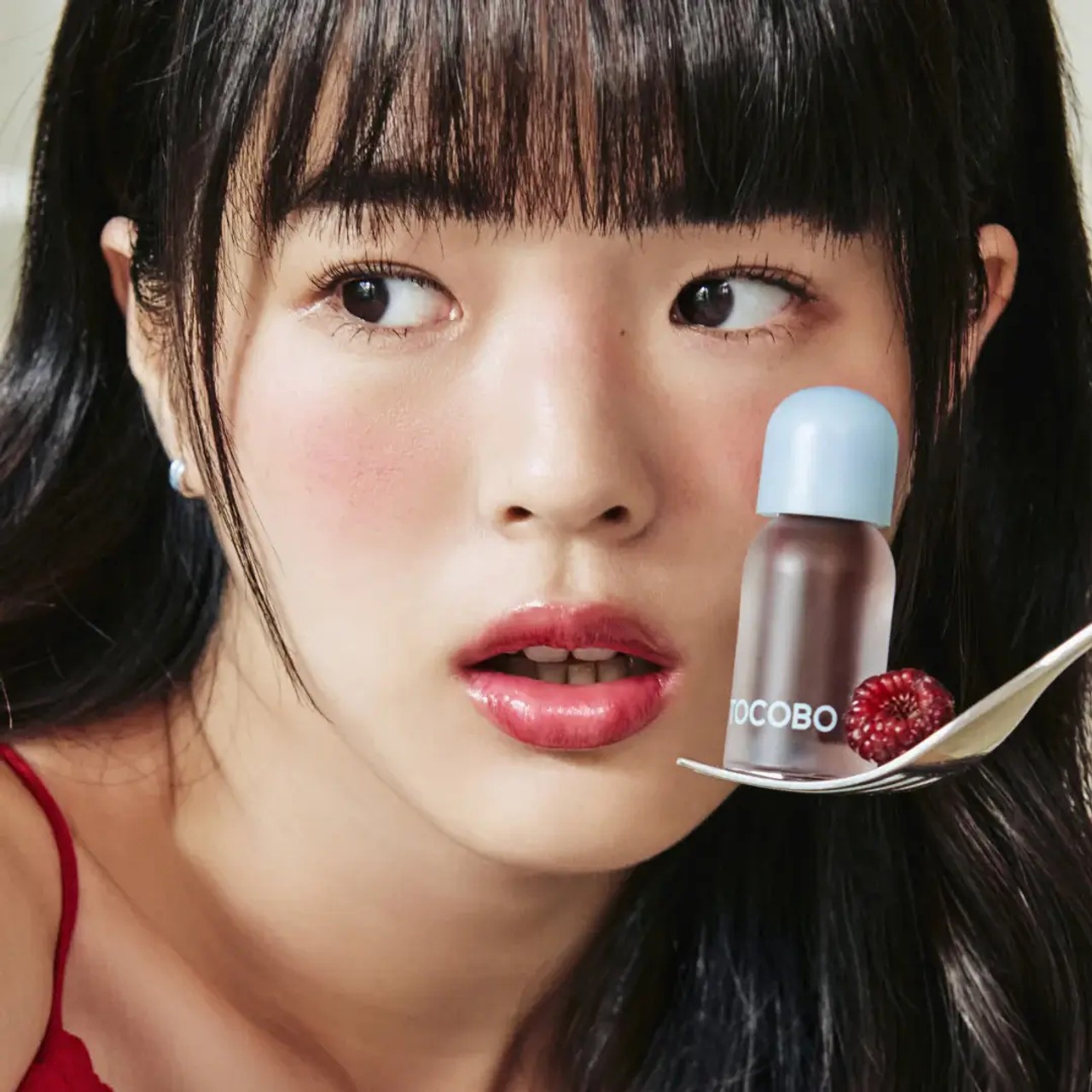 Tocobo Juicy Berry Plumping Lip Oil 07 Plum Jam being held by model