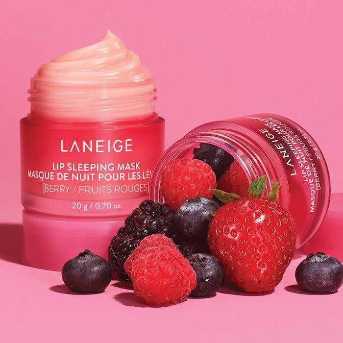 Laneige Lip Berry Sleeping Mask on its side, spilling out fresh blueberry, raspberry and strawberry