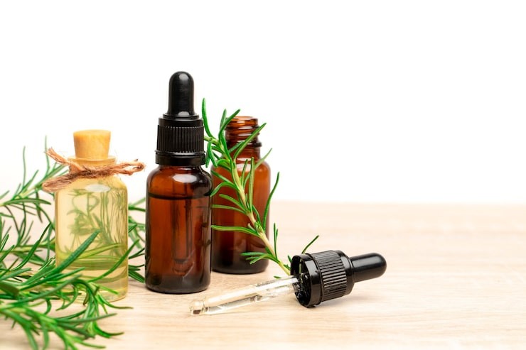 Vibrant rosemary branches adorning bronze essential oil bottles