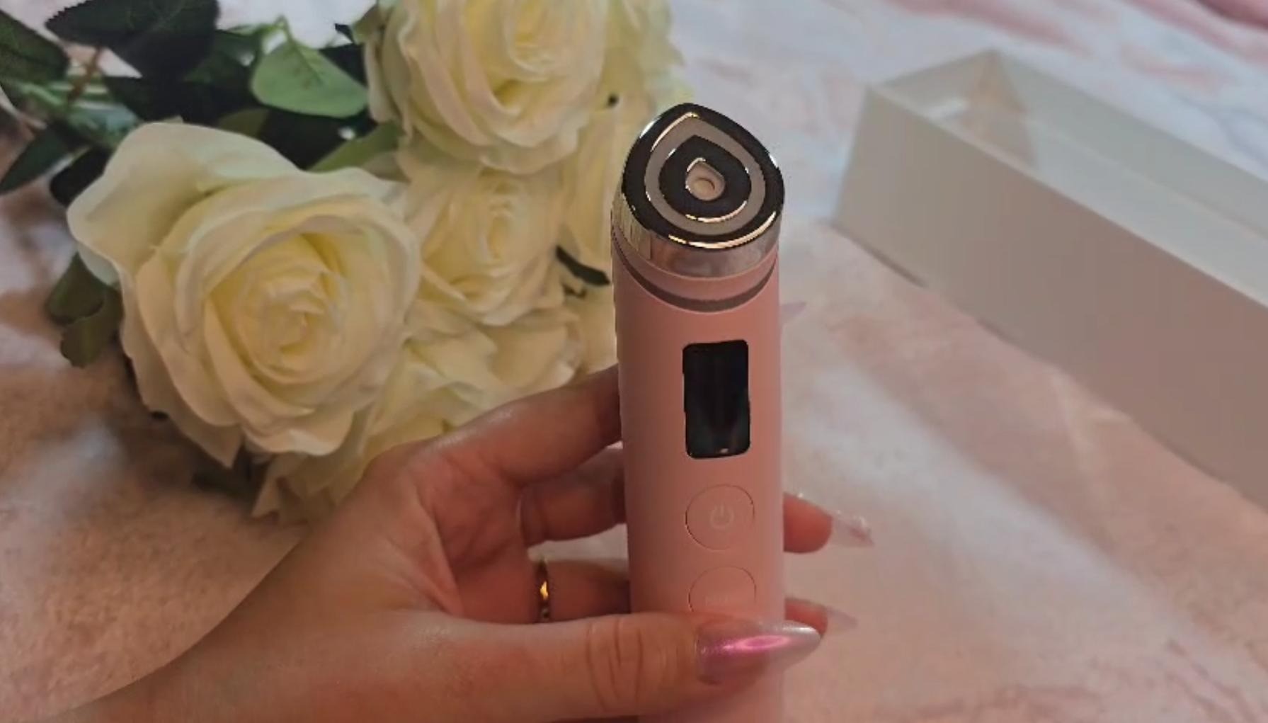 Medicube Age-R Booster Pro Pink being held to cheek of young woman