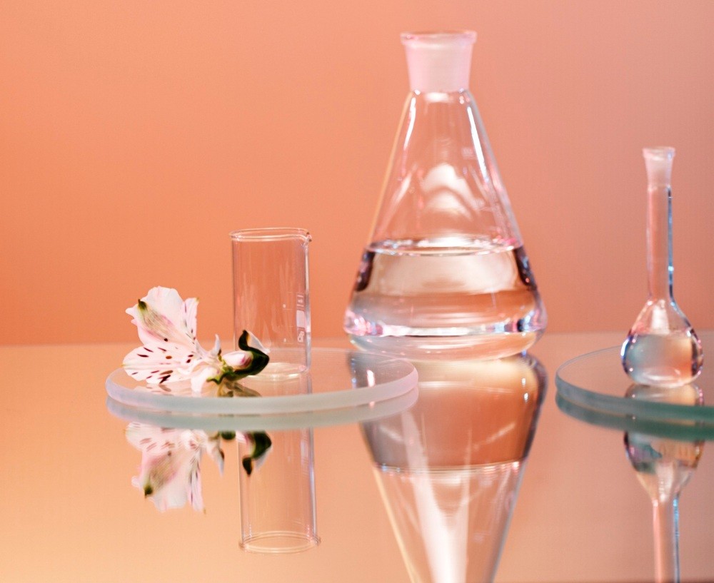 Scientific set-up with glass vials, conical flask and flower