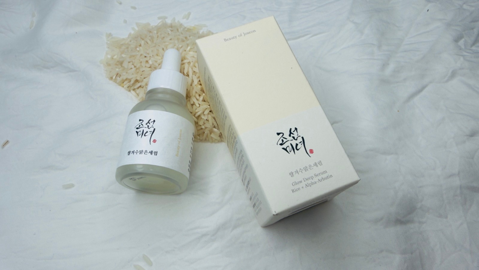 Beauty of Joseon Glow Deep Serum sitting on a white, fabric backdrop
